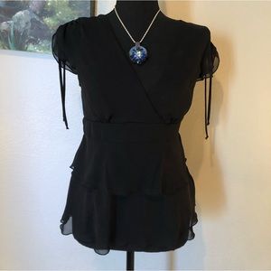 Classy, adorable, little black top. Cinched at the waist. V-neck.